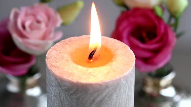 Beautiful candle and eustoma flowers in the background. 