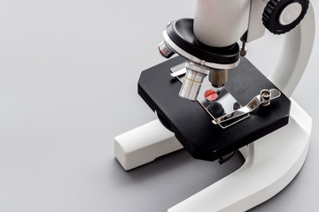 Microscope medical reserch. Blood sample for analysis. Grey table copy space