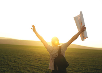 Young tourist traveling and studying the world map at sunset. Trip, travel, tourism concept