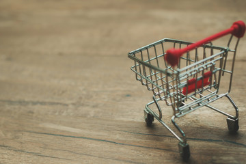 Empty shopping cart on wooden copy space