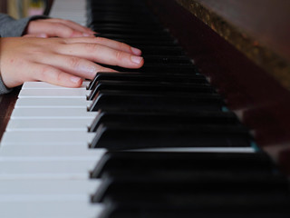Fototapeta na wymiar Practicing on piano, Teenager's hand, black and white keys, Concept developing finger's motion skill,