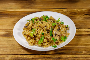 Tasty risotto with mushrooms on wooden table