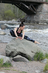 The girl practices yoga on the background of a beautiful waterfall. Sunny, spring day.
Concept: healthy lifestyle,