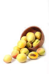 Fresh ripe apricots in wooden bowl isolated on a white background.