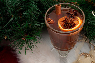 Winter aromatic drink and hot beverage concept with glass of mulled wine or grog, cinnamon sticks,...