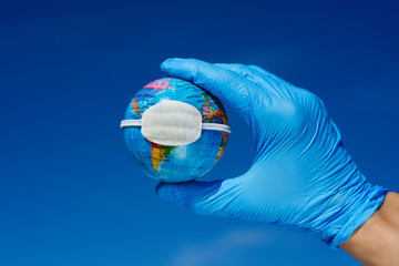 man wearing gloves showing a globe with a mask