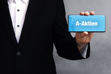 A-Aktien. Geschäftsmann im Anzug hält ein Smartphone in die Kamera. Der Begriff A-Aktien steht auf dem Handy. Konzept für Business, Finanzen, Statistik, Analyse, Wirtschaft