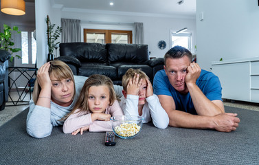 COVID 19 Outbreak. Bored and frustrated family watching tv at home feeling depressed  Mental health...