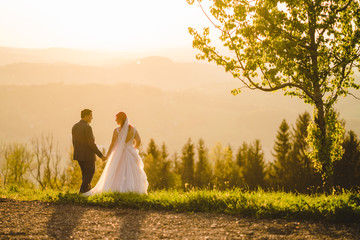 Verliebtes Brautpaar in schöner Landschaft bei Sonnenuntergang