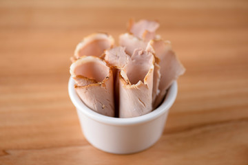 Pieces of boiled pork cooked with spices and rosemary served in a bowl.