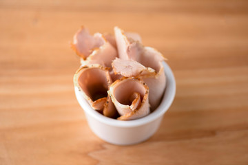 Pieces of boiled pork cooked with spices and rosemary served in a bowl.