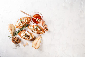 The concept of oriental cuisine. National Italian Toast with cheese, pear, honey and nuts. Delicious breakfast or snack on a light background, top view