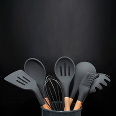 Kitchen utensils background with copyspace, home kitchen decor concept, black kitchen tools, rubber...