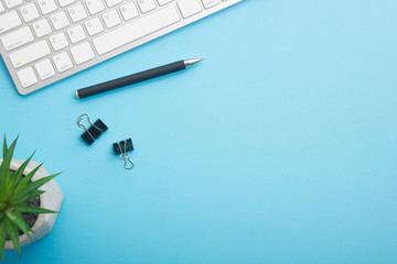 Blue desk office with laptop, smartphone and other work supplies with cup of coffee. Top view with...