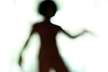 Blurred silhouette of human body look like alien.