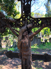 Rusty old crucifix covered in vines