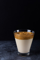 Dalgon coffee in a glass against a dark background.