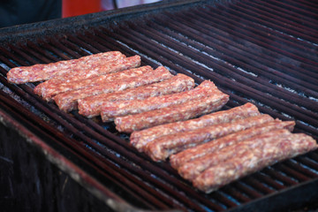 Chef preparing meat on the grill, during outdoor outside food festival, food truck
