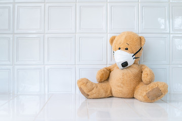 Teddy bear with face mask on white background. Concept of home school, isolation. Staying at home. Corona virus.