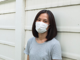 young Asian woman wear mask protect covid corona virus outdoor for social distancing