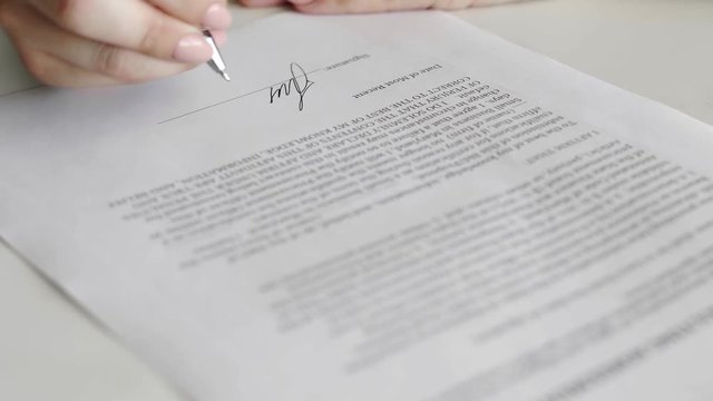 Businesswoman is signing consulting agreement. Person heand signs the document