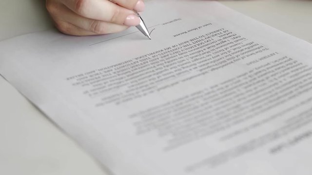 Politician woman is signing draft law. Person heand signs the document