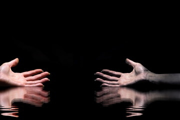 Four hands on a dark background in the light 5