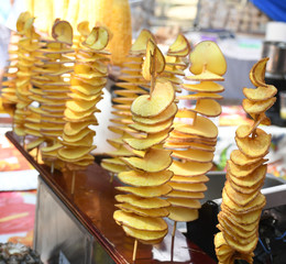 Fried swirl potato spiral on a stick during street food festival.