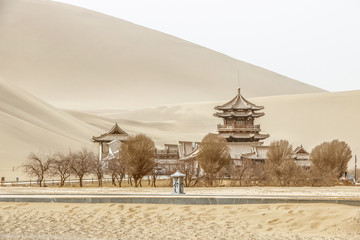 DUNHUANG,CHINA-MARCH 11 2016: Temple at Mingsha shan Gobi desert, sand mountain and Crescent moon lake in Dunhuang, silk road at Gansu, northwest of China - 346113268