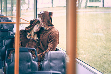 Obraz na płótnie Canvas young couple in bear costumes. guy and girl in transport cuddle.