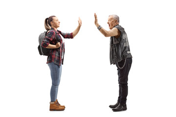 Female student gesturing high-five with a mature punk man