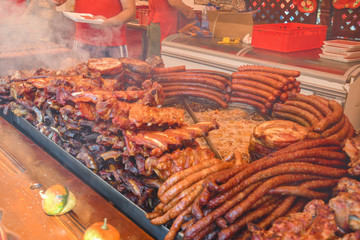 Chef preparing meat on the grill, during outdoor outside food festival, food truck