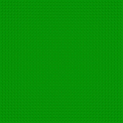 Green base template of plastic construction brick. Plastic toy blocks background in green. Construction plate base for children's toys. Repeating texture and empty field for bricks installation