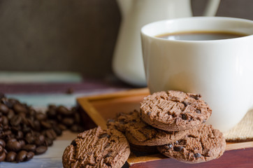 Closeup of chocolate cookies and a cup of coffee and.coffee beans. symbolic image. concept for a tasty snack. sweet