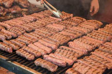 Chef preparing meat on the grill, during outdoor outside food festival, food truck