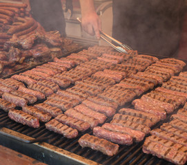Chef preparing meat on the grill, during outdoor outside food festival, food truck