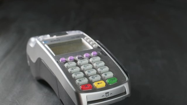 The user makes payment by credit card. Swipe to the terminal of non-cash payment. Man hand with credit card swipe through pos terminal. Banking services of electronic money. Enter PIN code