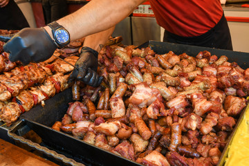 Chef preparing meat on the grill, during outdoor outside food festival, food truck
