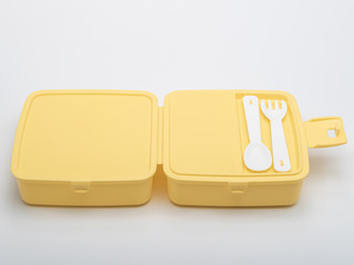 bright yellow lunch box with compartments with individual Cutlery