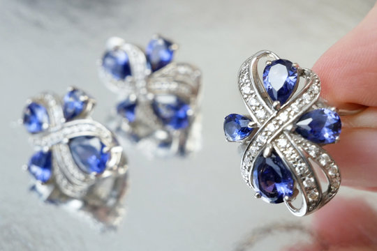 jewelry set with ring and earrings with tanzanit stones on silver background, pawnshop concept, jewerly shop concept