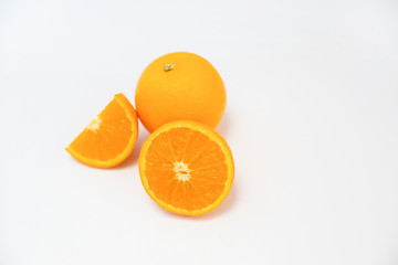 Composition of whole orange and cut orange laying together isolated on white background. Close-up side view. Citrus fruit and healthy food concept