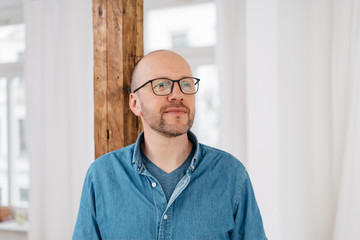 Middle-aged man standing thinking deeply