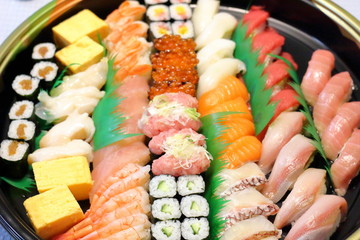 Overhead view of Japanese food sushi . several rolls with tuna, salmon and shrimp. Japanese delivery sushi set at home party.