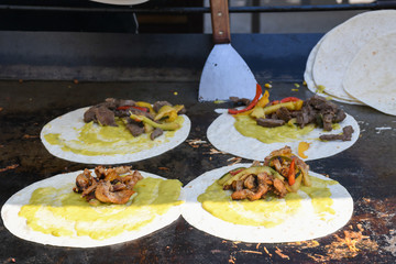 The process of preparing a quesadilla, traditional Mexican dish. Outdoor outside setting