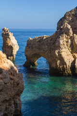 Fototapeta na wymiar Formación de rocas en el mar con un arco de piedra natural en Punta Piedade, Portugal