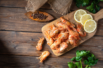Shrimp on a wooden Board on a brown wooden table. Greenlandic prawns	