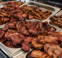 Chef preparing meat on the grill, during outdoor outside food festival, food truck