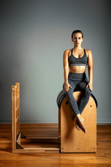 Pilates trainer exercises on a pilates barrel. Body training, perfect body shape and posture correction opporno motor apparatus. Copy space.