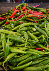 Green and red chili on a counter top of a store during food festival market.