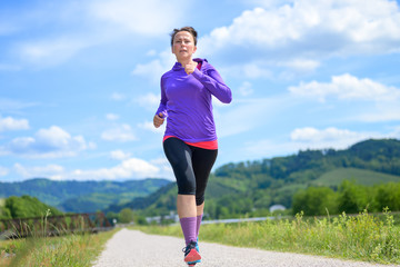 Fit athletic middle-aged woman out jogging